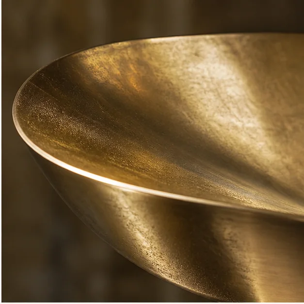 Close-up of a brass sculpture showing warm tone, surface detail, and subtle reflections