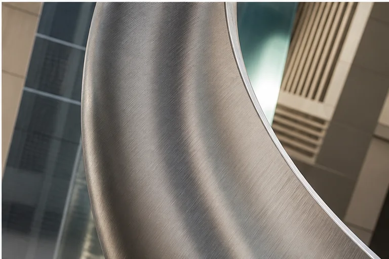 Brushed stainless steel sculpture with a refined directional texture