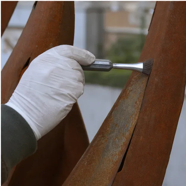 Close-up of visible rust treatment on a metal sculpture surface