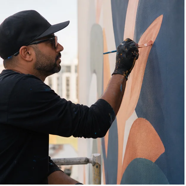Artist painting a commissioned mural in the UAE